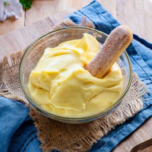 Pastry cream in a bowl with a ladyfinger cookie.