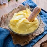 Pastry cream in a bowl with a ladyfinger cookie.