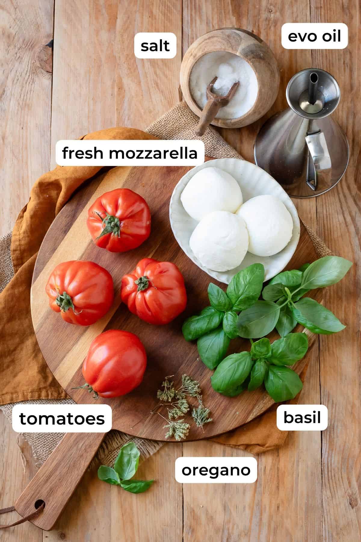 Caprese salad ingredients laid on a wooden surface.