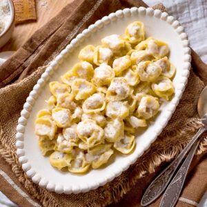 Tortellini alla panna on a plate with forks on the side.