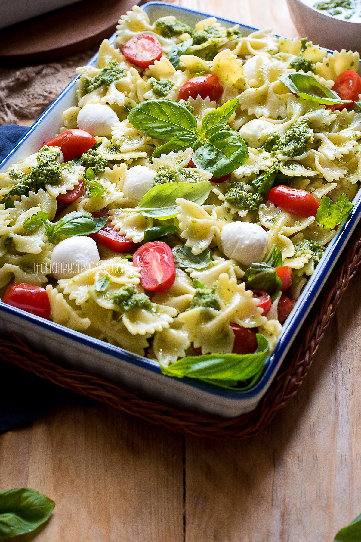 Pasta Caprese in a serving dish with a blue lining.