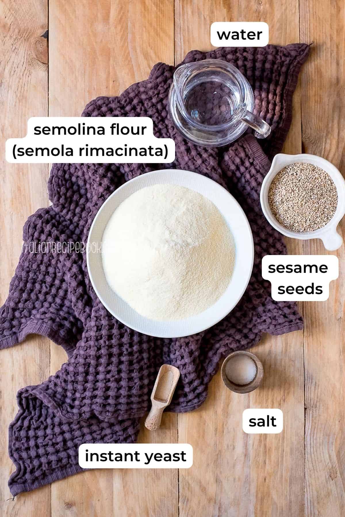 Ingredients needed for semolina bread laid on a wooden surface.