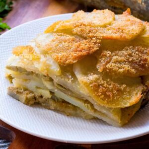 Potato artichoke gratin slice on a plate.