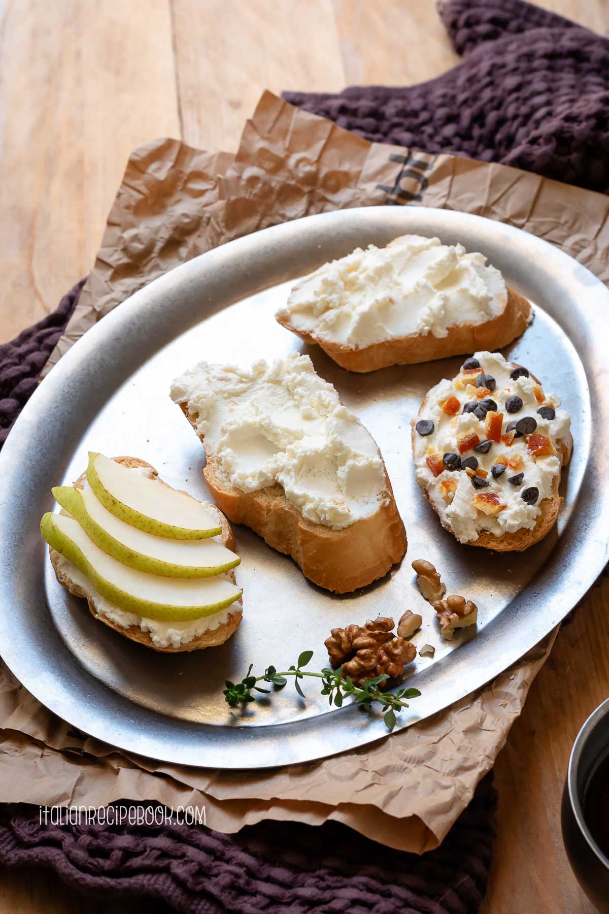 Crostini topped with ricotta on a metal tray.