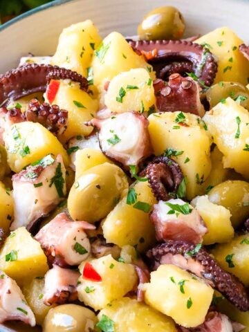 Octopus salad with potatoes and olives in a salad bowl.