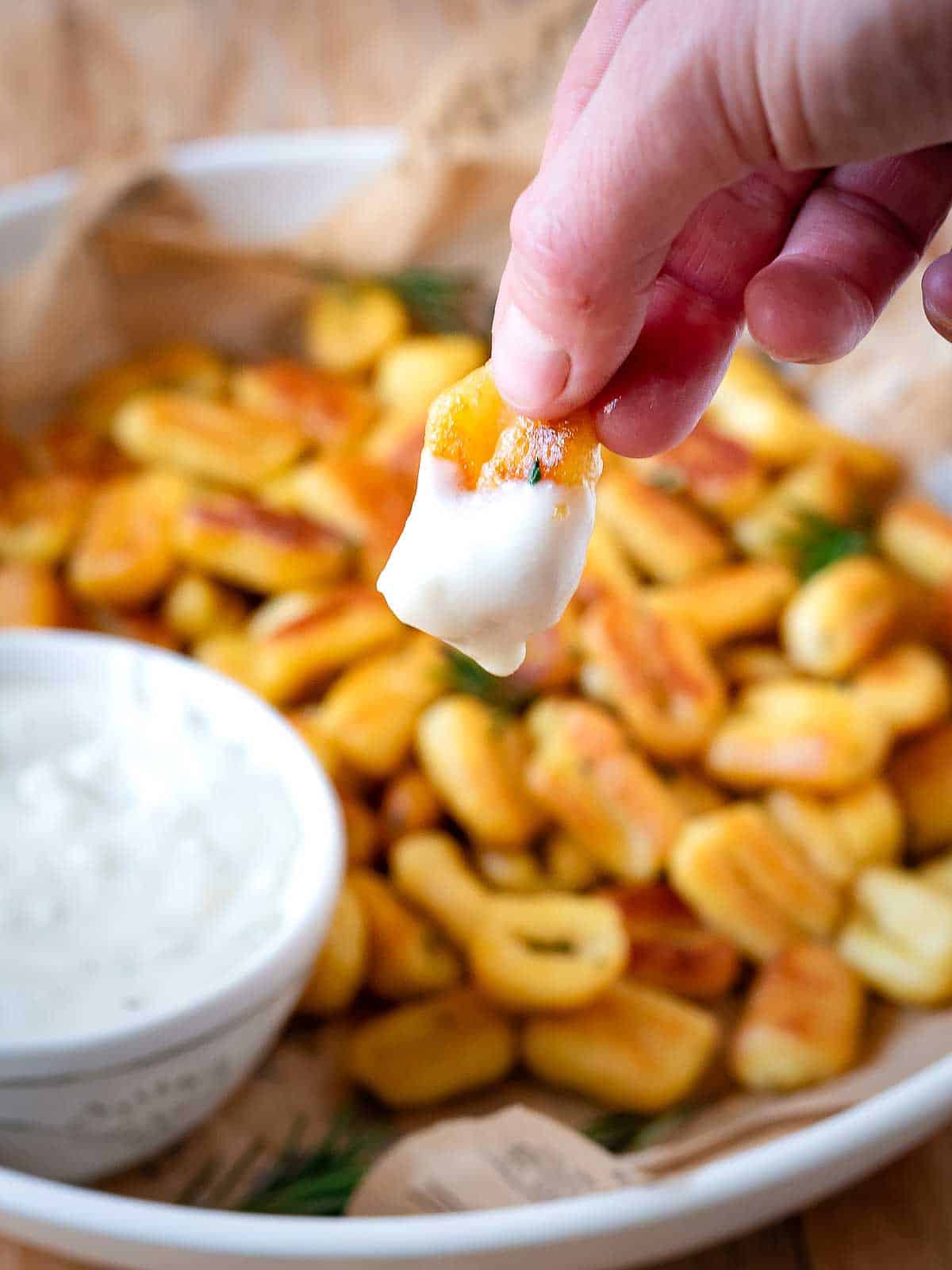 Fried gnocchi dipped in a creamy sauce.