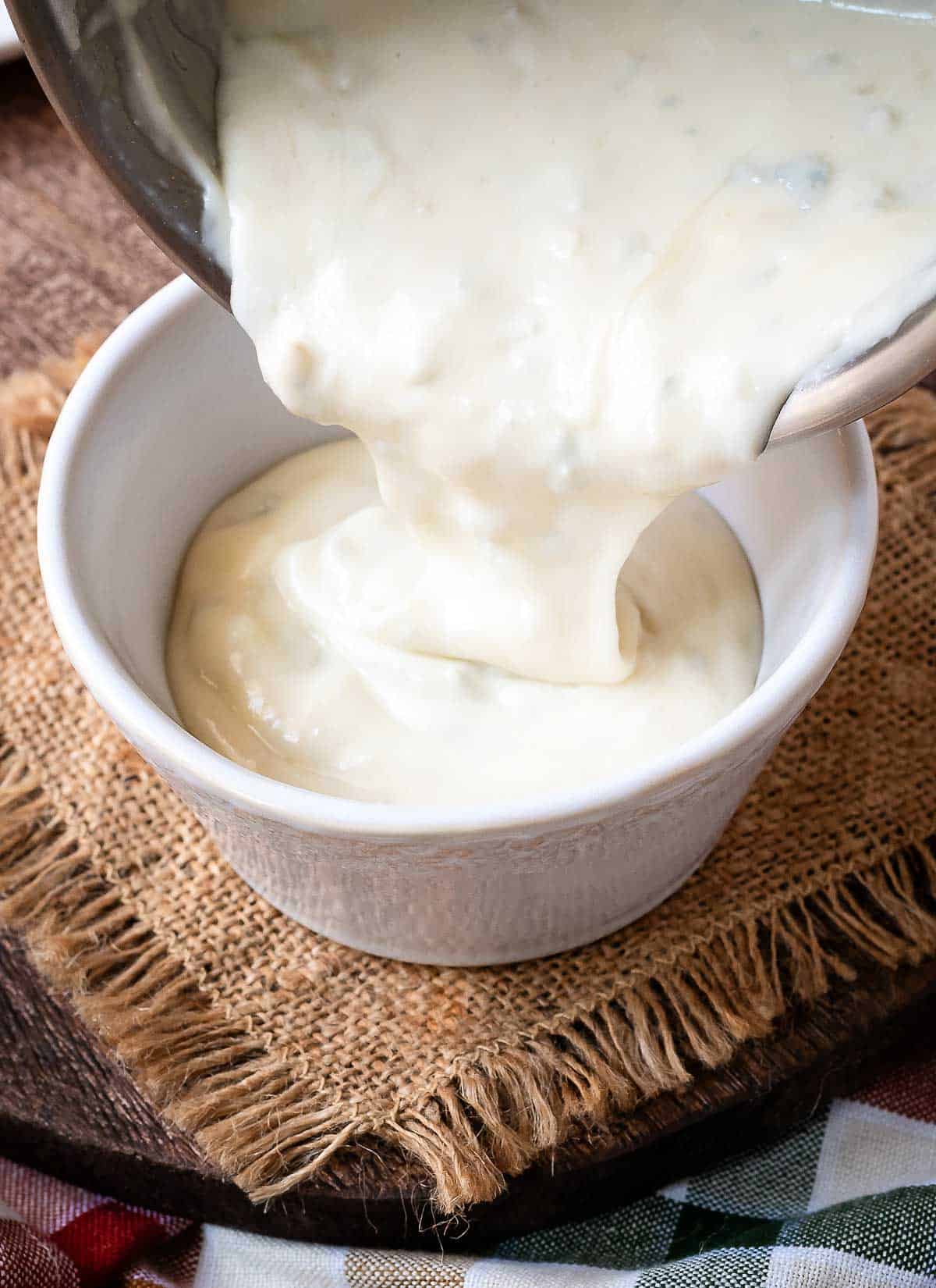 Pouring Gorgonzola sauce into a bowl.