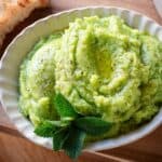 Fava bean pesto in a bowl garnished with mint leaves.