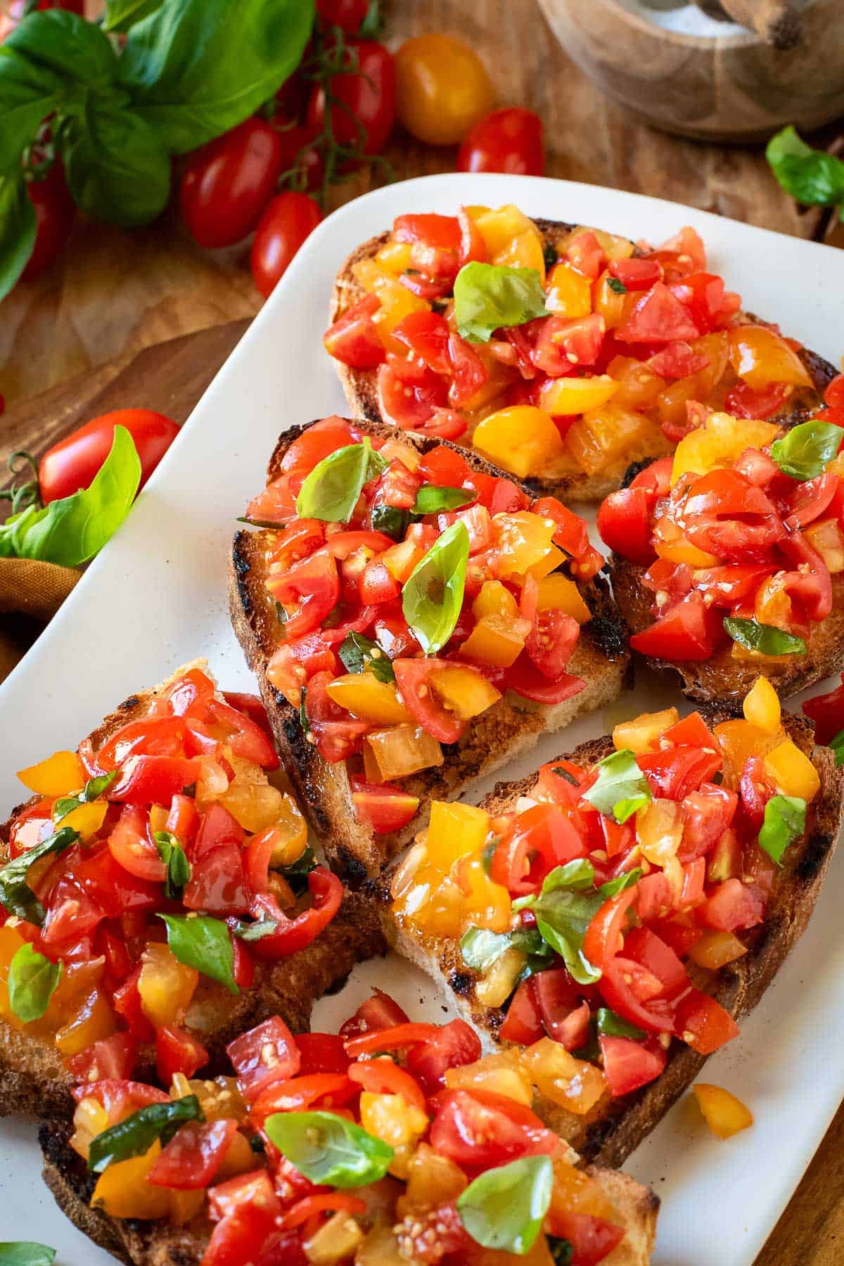 Cherry tomato bruschetta garnished with basil leaves.