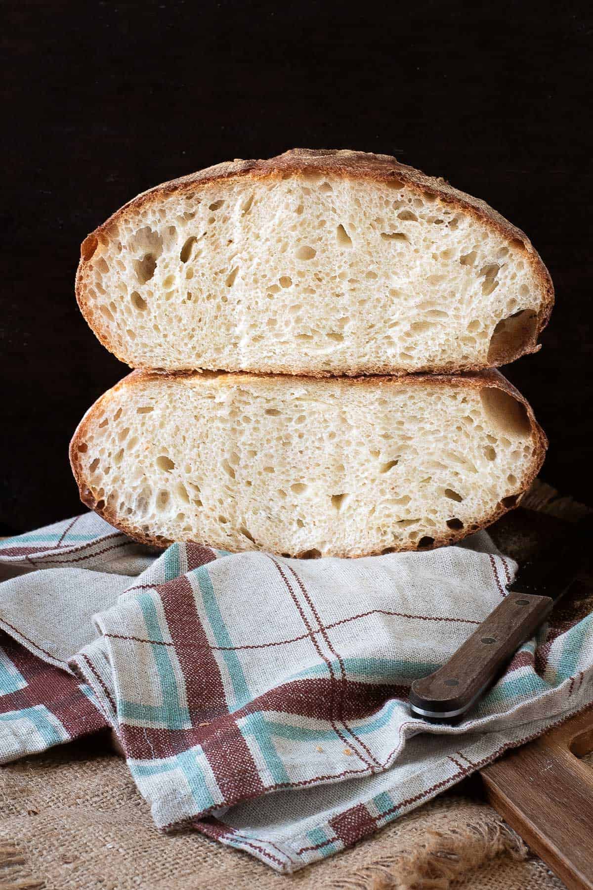 Pugliese bread loaf cut in half and stacked on each other.