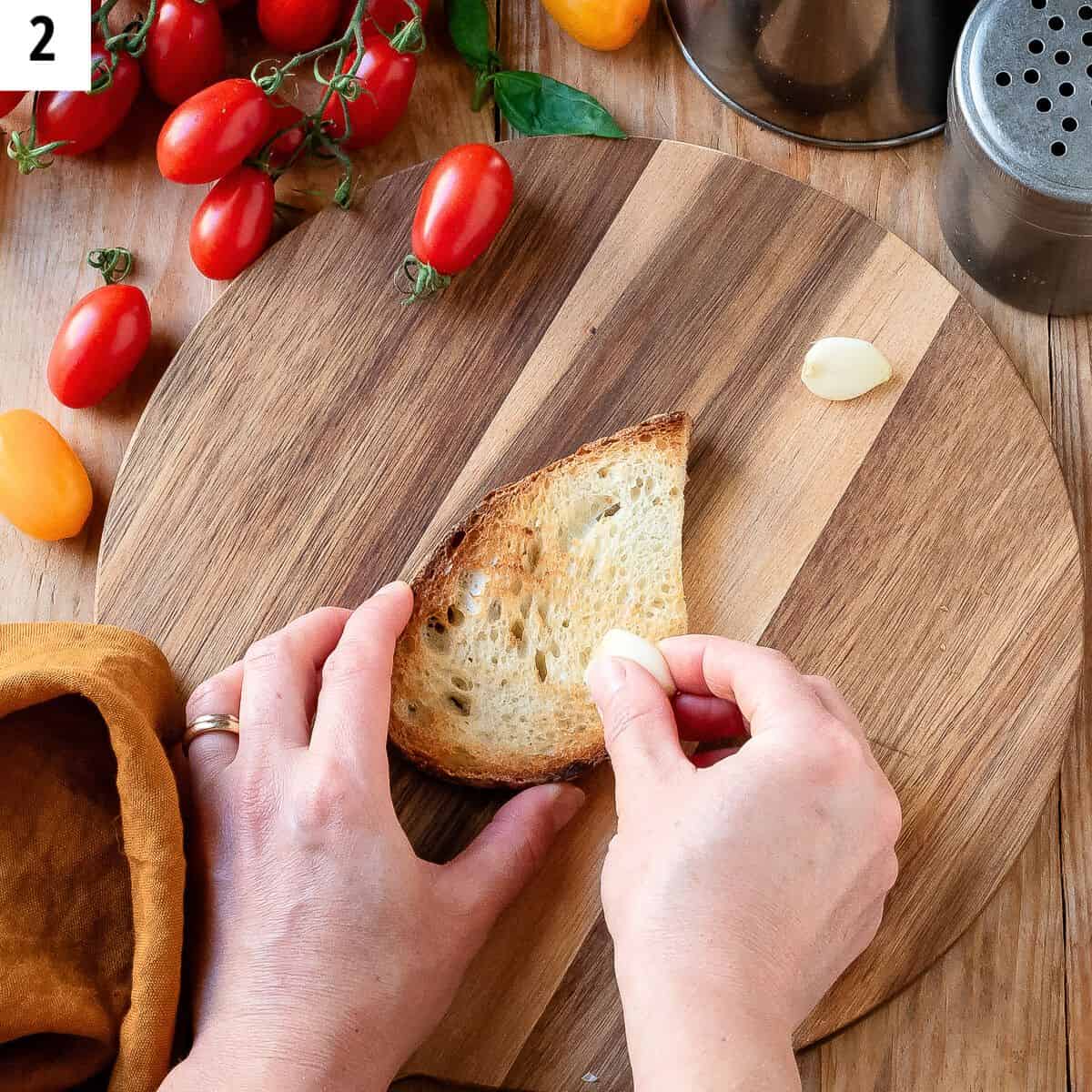 Rubbing toasted bread with garlic.