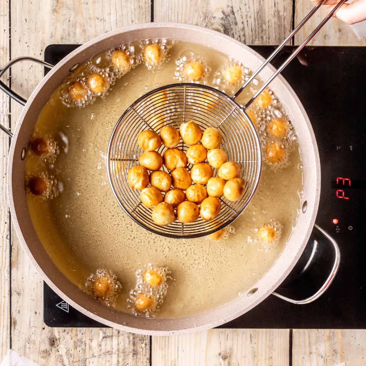 Fried struffoli in hot oil.