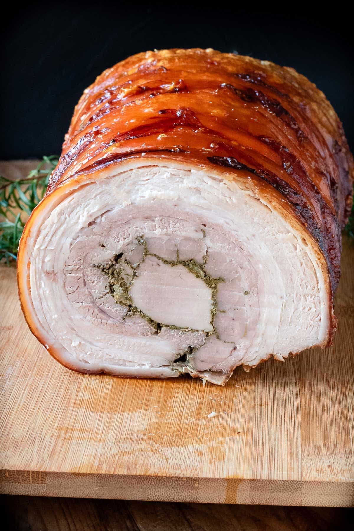 Porchetta roast on a wooden cutting board.