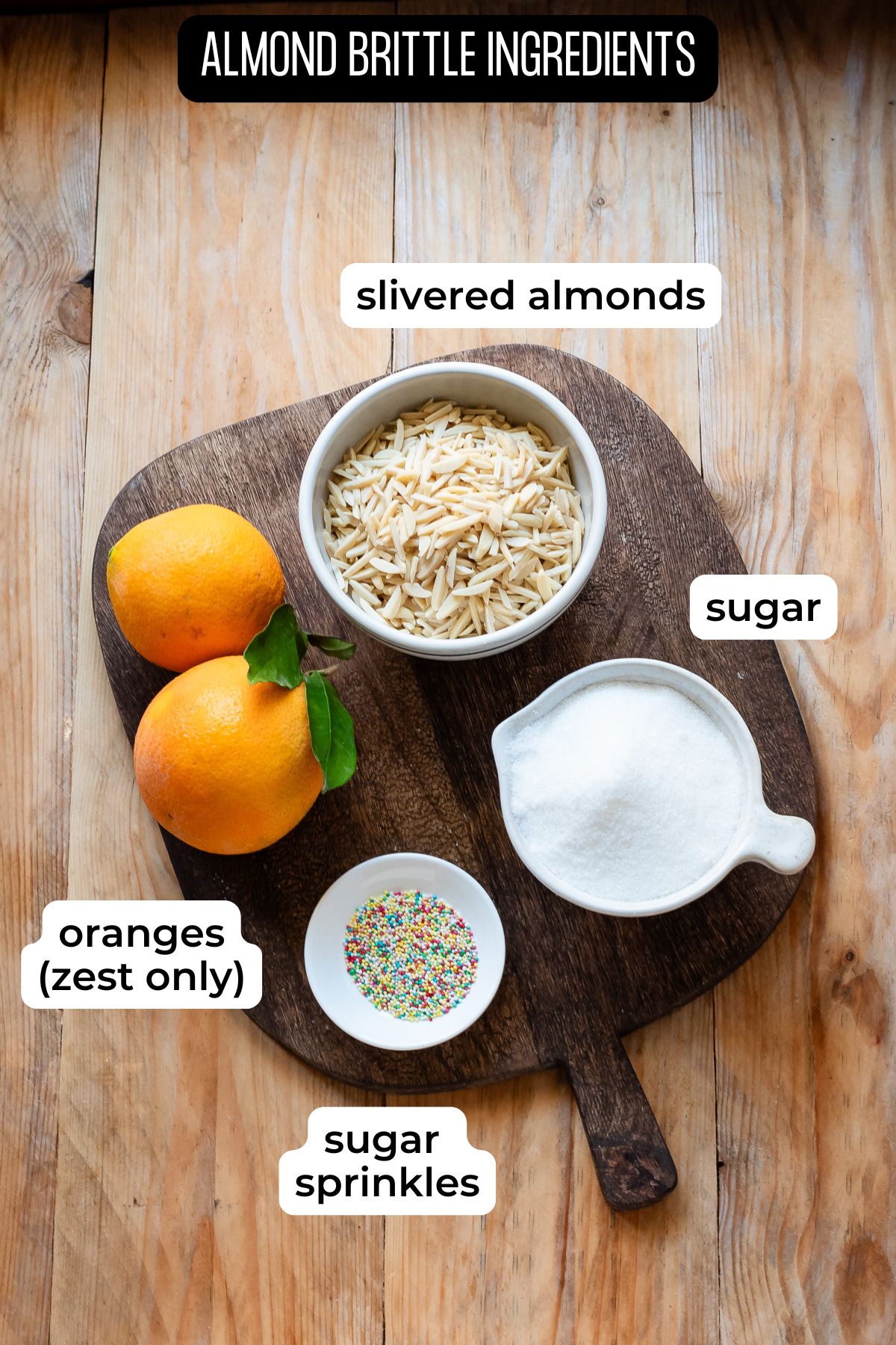 Ingredients needed to make almond brittle laid on a wooden surface.