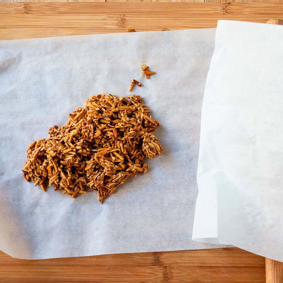 Hot almond brittle paste on parchment paper.