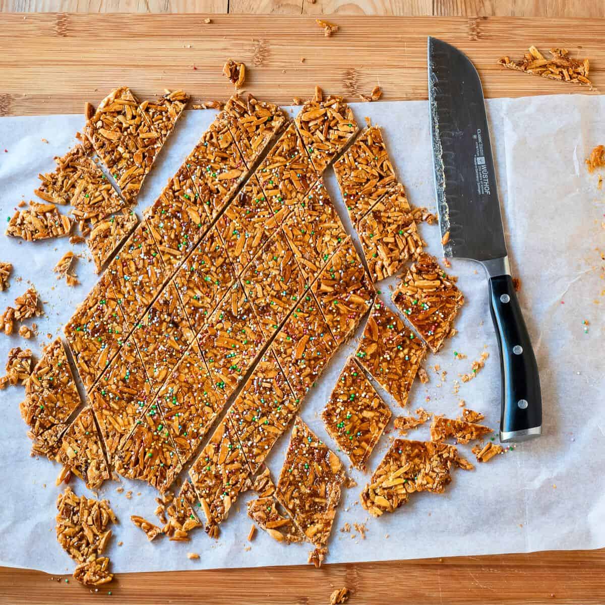 Almond brittle roughly cut in a wooden board.