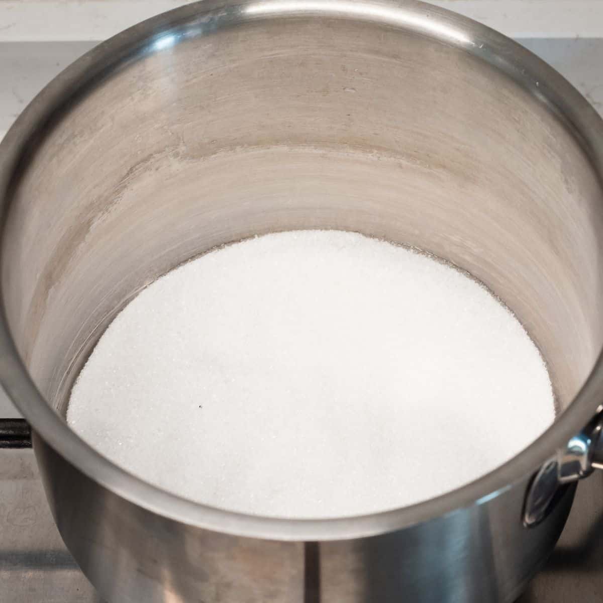 Melting thin layer of sugar in a pot.