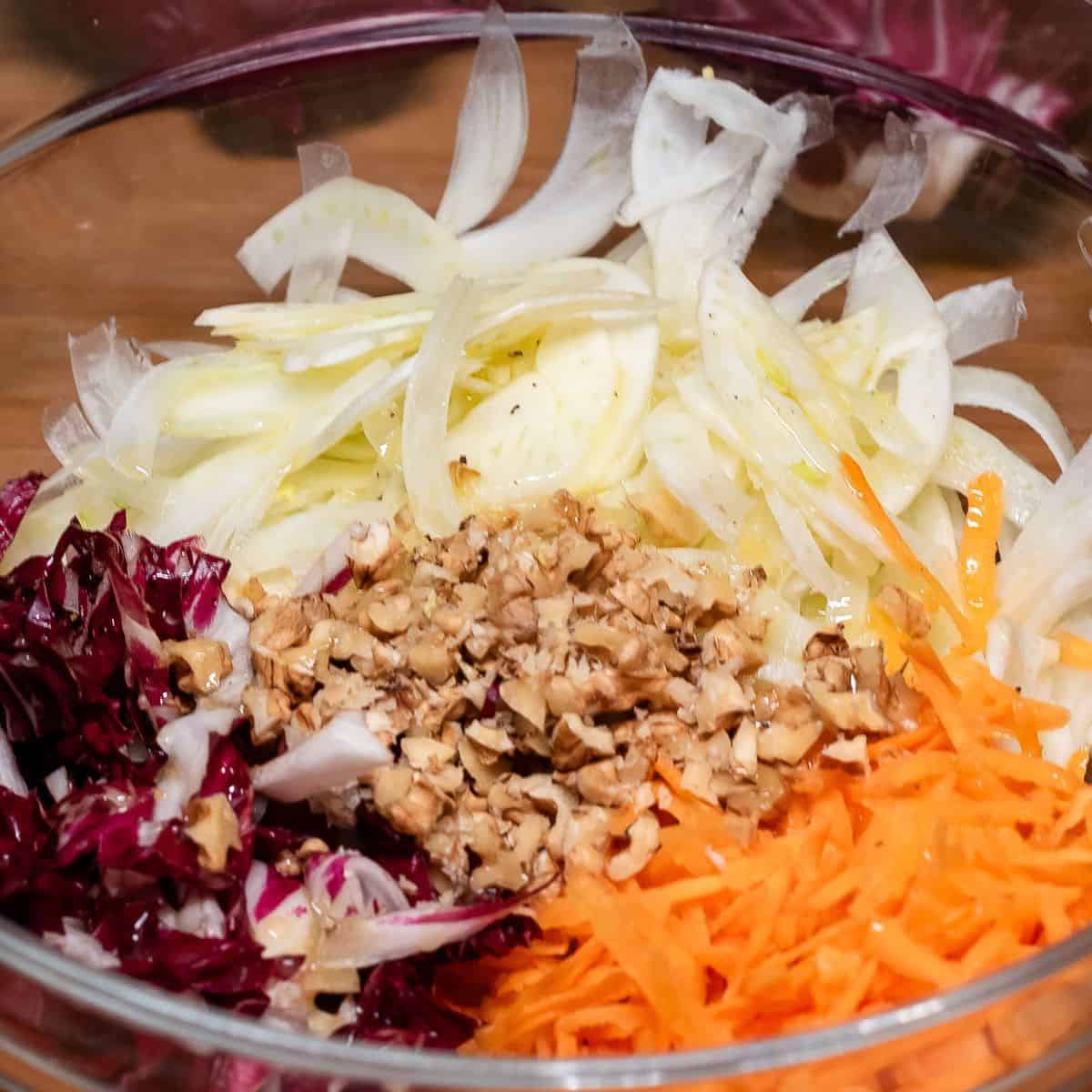 Shredded vegetables and walnuts in a bowl.