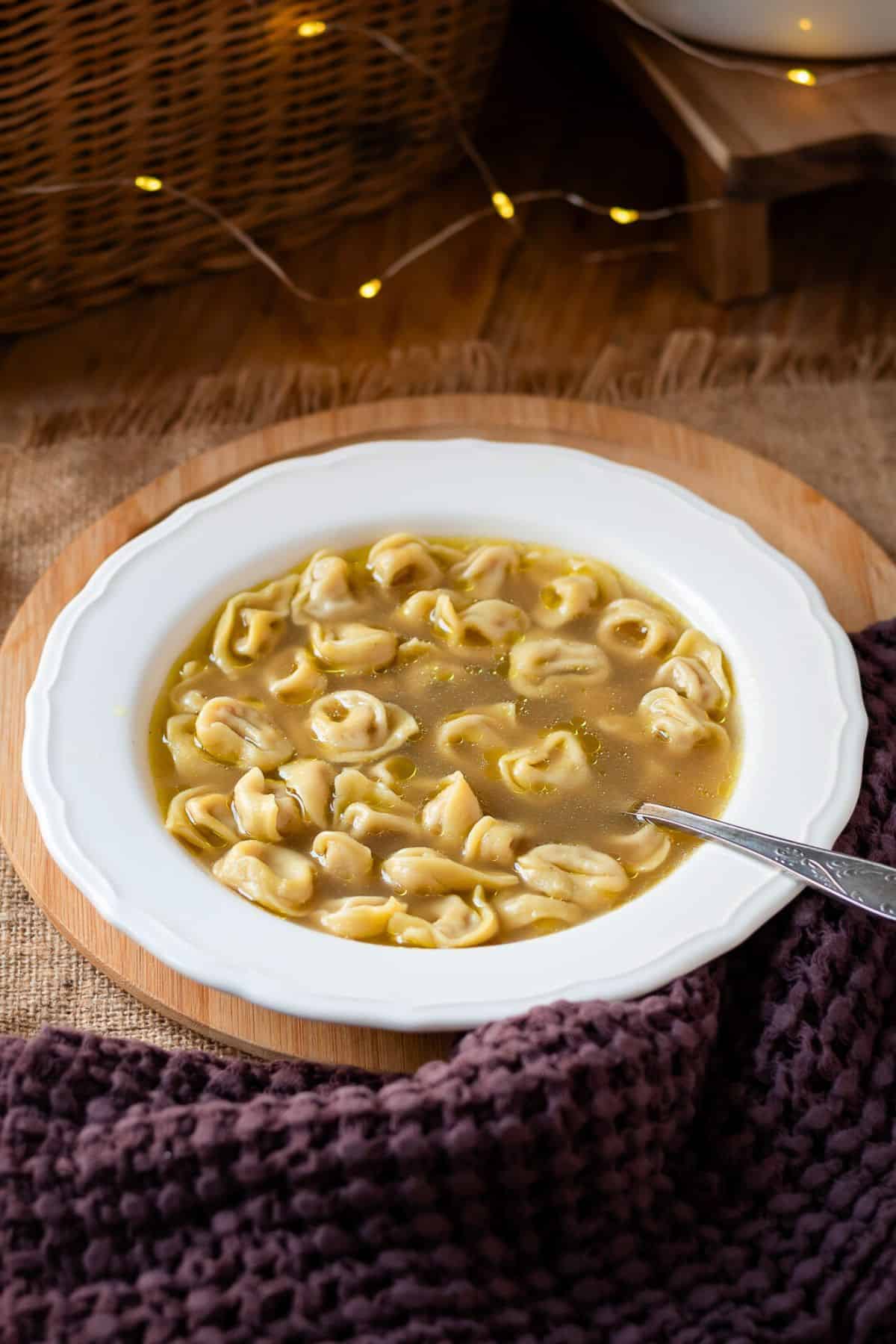 Tortellini in brodo in a white bowl.