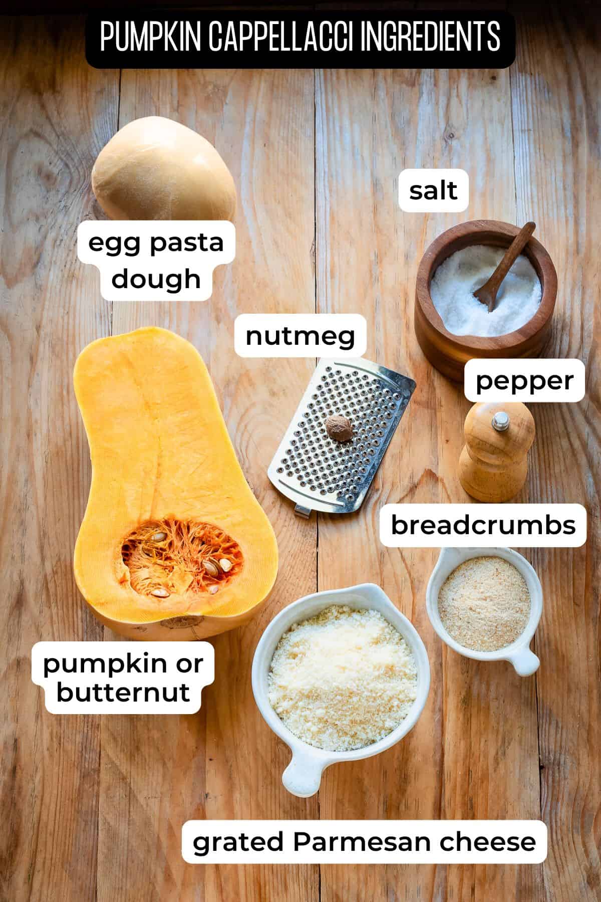 Ingredients needed for pumpkin cappellacci laid on a wooden surface.