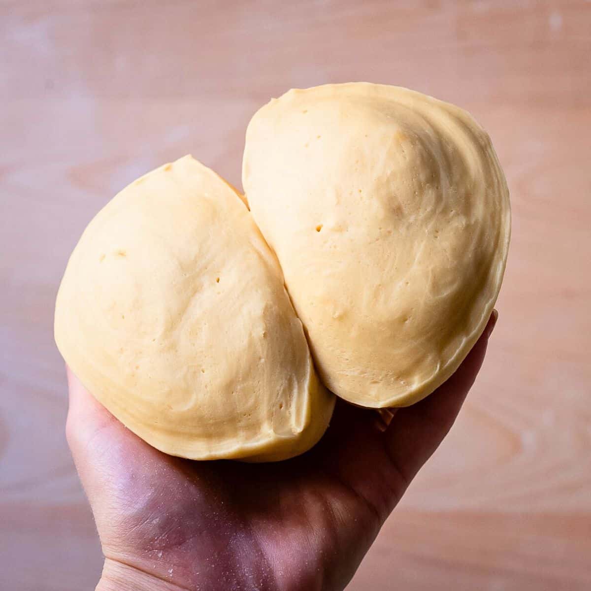 Holding perfect homemade pasta dough in a hand.