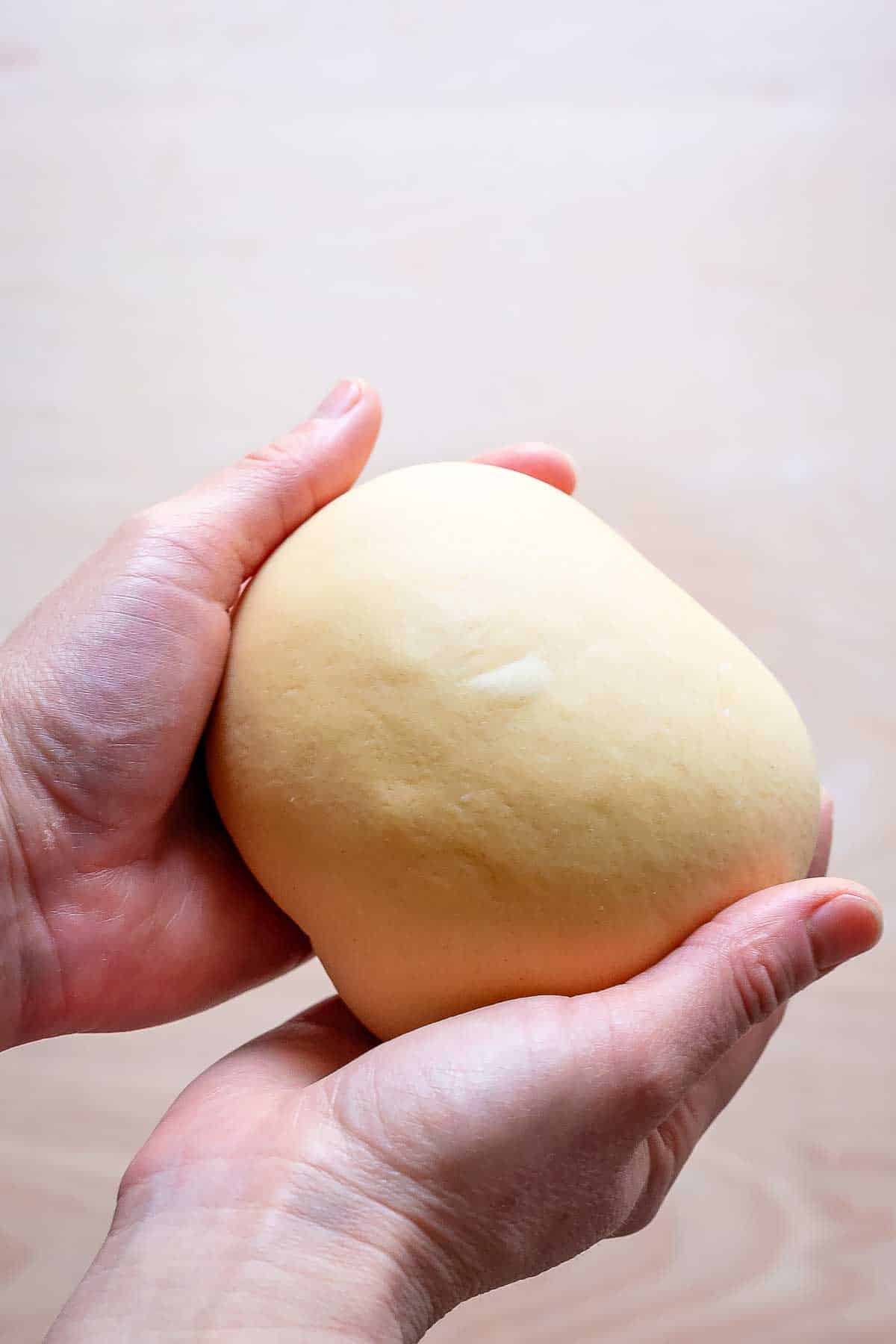 Holding a smooth ball of homemade pasta dough. 